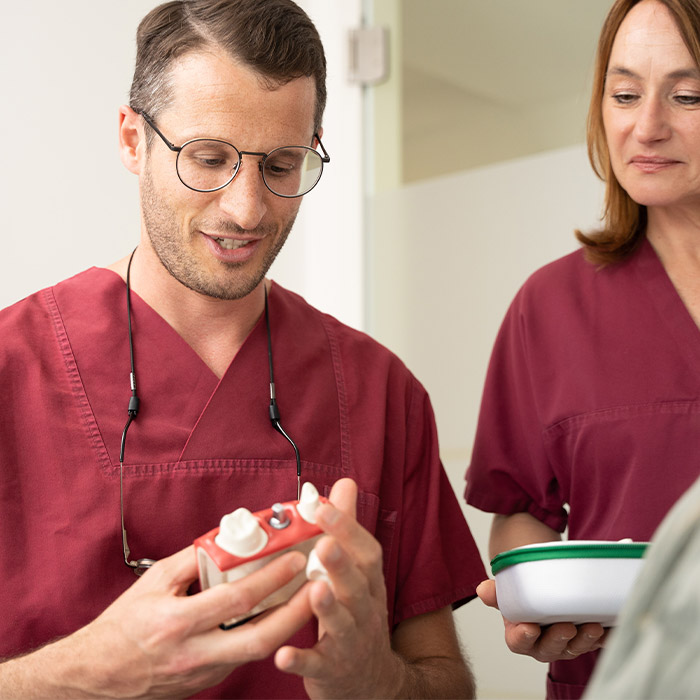 Dr. Stefan Feldmann mit Implantat-Modell in der Hand. 